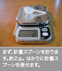 まず、計量スプーンを計ります。約２ｇ。 はかりに計量スプーンを乗せます。